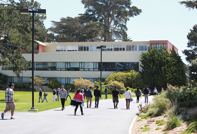 SF State students walking on the path leading toward the health and social sciences building.